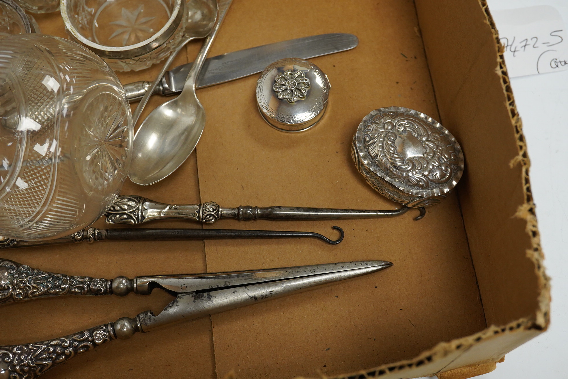 Five assorted silver topped toilet jars, a pair of silver mounted glass salts, a late Victorian repousse silver oval pill box, two modern silver pill boxes, four silver spoons, a silver handled knife, a pair of silver ha